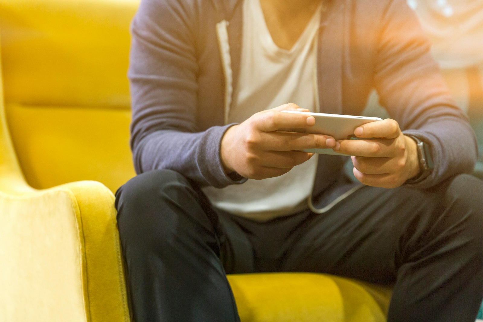 A man on a sofa checking information on his smartphone