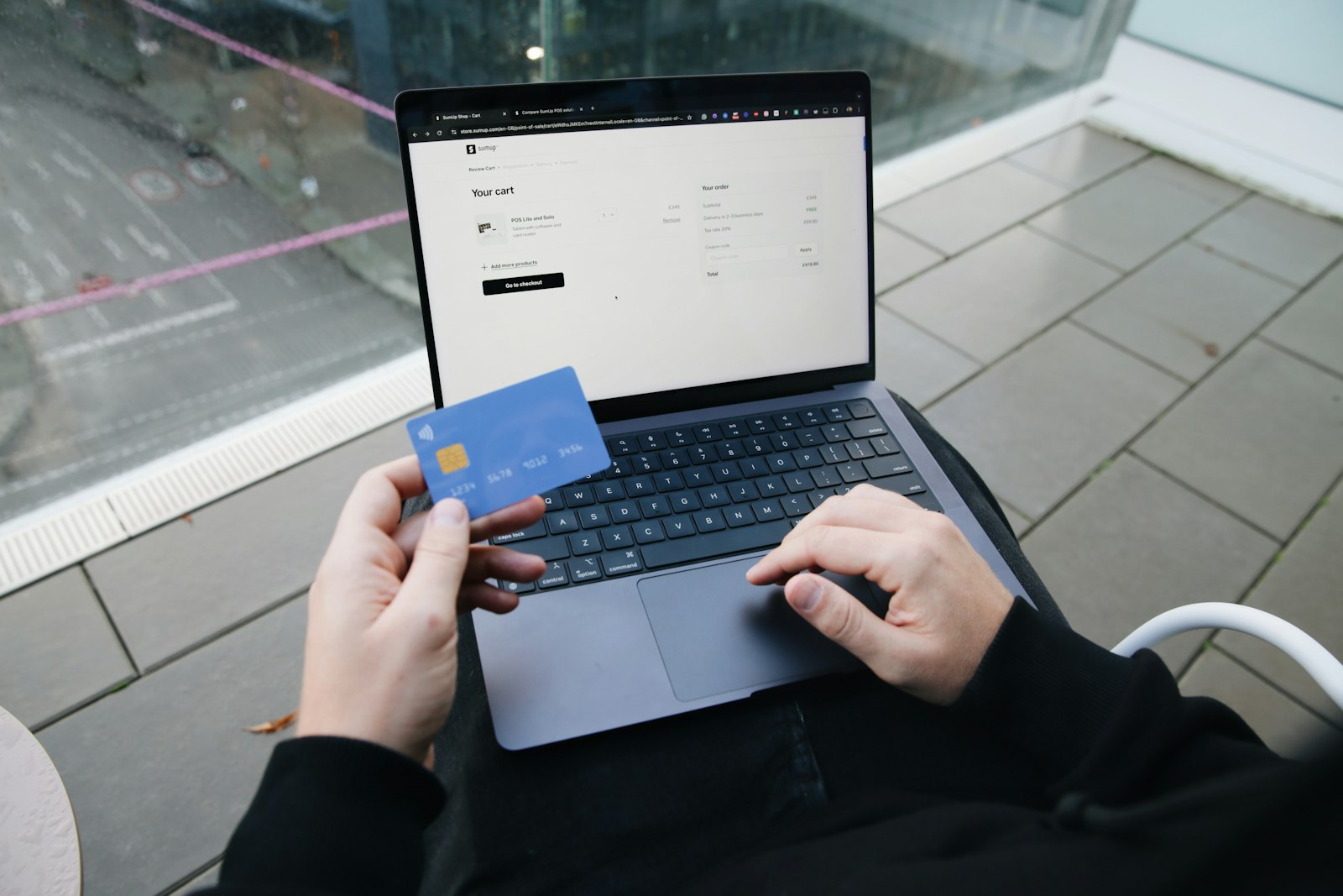 A person paying online with a bank card on a laptop